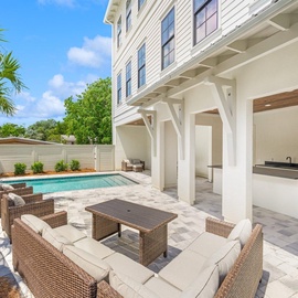 Your private oasis awaits with a sparkling pool, elegant covered patio, and outdoor kitchen perfect for entertaining under tropical skies.