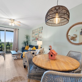 Relax in your bright, coastal-inspired living space with stylish wicker lighting and comfortable seating overlooking lovely views.
