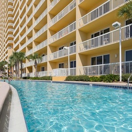 Resort-style living with sparkling pool, tropical palms, and spacious balconies overlooking the pristine waters.