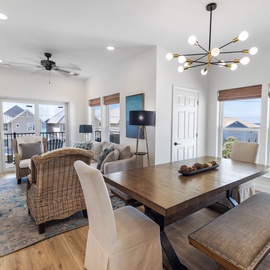 Gather around your dining table and living area where sunlight pours through oversized windows, revealing sparkling ocean views and coastal palms just beyond. Your open layout invites relaxation and connection.