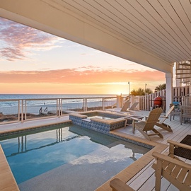 Luxurious oceanfront terrace with private pool where stunning sunrises paint the sky in golden hues above pristine beach.