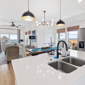 Bright, open-concept living where your chef's kitchen flows seamlessly into a cozy dining and lounge space. Gleaming countertops, modern fixtures, and natural light create the perfect backdrop for your vacation meals and moments together.