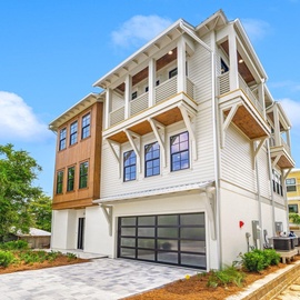 Modern coastal architecture with clean lines and natural wood accents creates an inviting beachside retreat in this charming neighborhood setting.