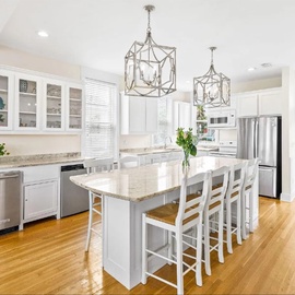 Step into this bright, elegant kitchen where you'll love cooking together around the spacious island with gleaming countertops and modern appliances.