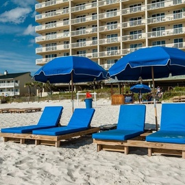 Beachfront property with convenient umbrella and lounge chair service right on the sandy shore.
