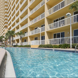 Crystal-clear pool surrounded by tropical palms creates your perfect oasis for relaxation and refreshing swims under sunny skies.