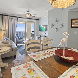 Your coastal retreat features warm beach decor and ocean views through sliding doors to your private balcony—perfect for morning coffee and sunset dining.