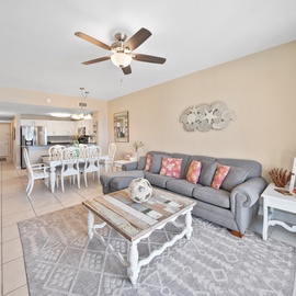 Unwind in your spacious living area with plush seating, coastal decor, and an open layout perfect for relaxation.