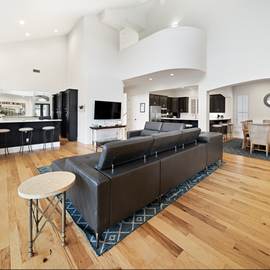 Step into your spacious open-concept haven, where sleek leather seating and warm hardwood floors create the perfect backdrop for memorable gatherings.