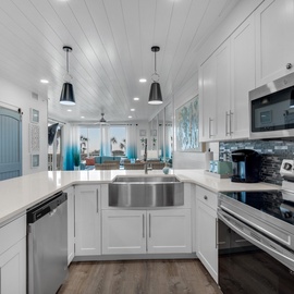 Your chef-worthy kitchen features gleaming granite counters, stainless appliances, and coastal charm with shiplap ceilings and ocean-blue accents.