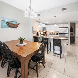 Your open-concept dining and kitchen space features a warm wooden table and modern appliances, perfect for sharing meals together.