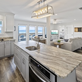 Your gourmet kitchen flows seamlessly into the living space, where marble counters and ocean views create the perfect backdrop for memorable meals.