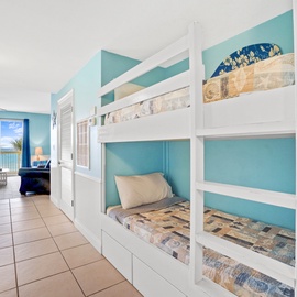Wake up to ocean views in your cheerful bunk room with custom white beds and soothing turquoise walls.