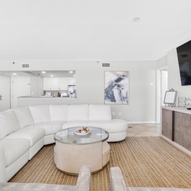 Your bright, open-concept living space features plush white sectional seating and seamless kitchen access for perfect relaxation.