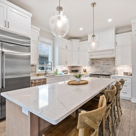 Your gourmet kitchen awaits with gleaming marble counters, professional appliances, and elegant pendant lighting for memorable meals.