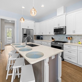 Your gourmet kitchen awaits with gleaming quartz counters, stainless appliances, and a spacious island perfect for morning coffee or evening meals together.