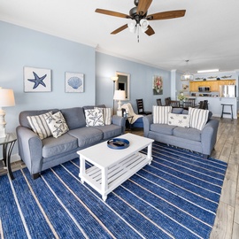 Unwind in your coastal-themed living space with plush seating, nautical touches, and an open layout that flows into the fully equipped kitchen.