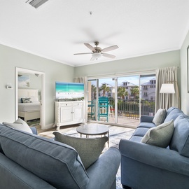 Sink into plush blue sofas while gentle ceiling fans keep you cool in this bright, coastal-themed living space.