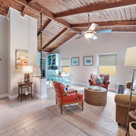 Unwind beneath stunning exposed wood beams in your spacious living room, where coastal colors and cozy seating create the perfect retreat.