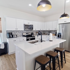 Step into your fully-equipped kitchen, bright and spacious with a large island perfect for morning coffee or preparing meals together.