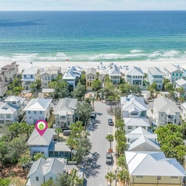 Aerial view of a charming beachfront community with colorful coastal homes just steps from pristine white sand beaches.