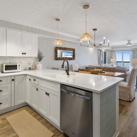 Your open-concept kitchen features gleaming white cabinets, stainless appliances, and a spacious island perfect for morning coffee and meal prep.