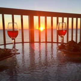 Sip your evening wine as golden sunset paints the sky, creating magical reflections on your private balcony table.