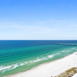 Stunning oceanfront view from the balcony showcases pristine white sand beaches and emerald waters stretching to the horizon.
