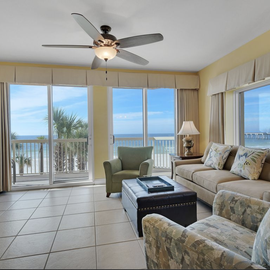 Relax in your bright living room with stunning ocean views through floor-to-ceiling windows and comfortable seating.