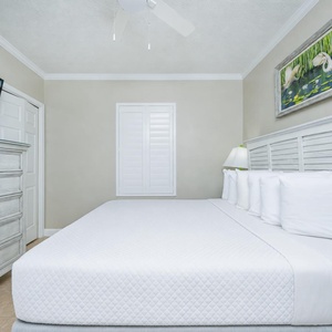 Relax in this comfortable guest room featuring a king bed, light decor, and a TV for your entertainment