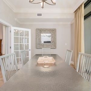 Dining area featuring a stylish table, elegant decor, and a breathtaking view of the tranquil waters beyond