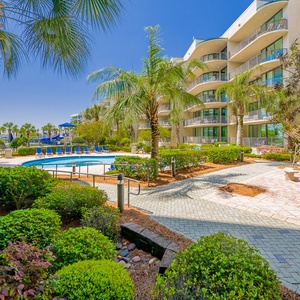 Relax amid lush greenery and the inviting pool area, soaking up the sunshine and coastal vibes