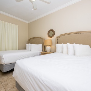 Inviting guest bedroom featuring two comfortable queen beds, soft linens, and a warm, welcoming vibe