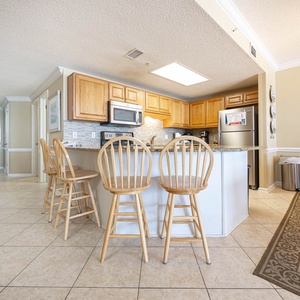 Gather around the breakfast bar with seating for four, perfect for casual meals or morning coffee in this inviting kitchen
