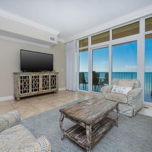 Unwind in the inviting living area, featuring a TV, cozy seating, queen sofa sleeper, and beachfront balcony access