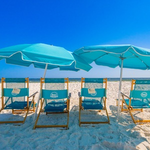 Relax on the soft sand with colorful umbrellas and lounge chairs, perfect for a day at the beach