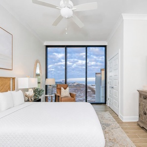Serene guest bedroom featuring a king bed, stylish decor, and large windows showcasing beautiful beach views