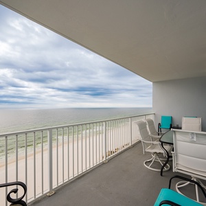 Enjoy breathtaking beachfront views from this balcony, featuring stylish seating and a glass table for relaxing moments