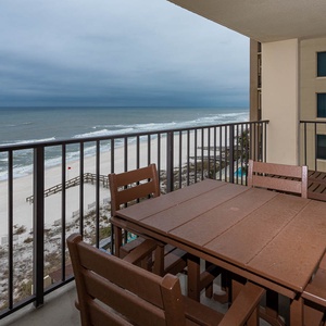 Enjoy the spacious balcony with comfortable seating and breathtaking views of the serene beach and gentle waves