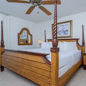 Relax in this elegantly decorated master bedroom featuring a king-size bed, stylish furnishings, and beach balcony access