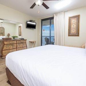 Relax in this inviting master bedroom featuring a king bed, stylish decor, and easy access to beautiful beachfront views