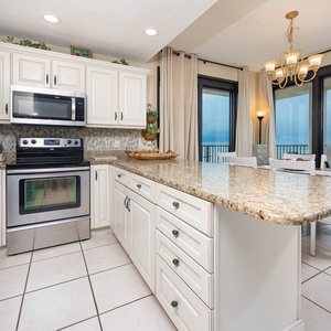 Cook and gather in this inviting kitchen featuring stainless appliances and a dining area with views of the beach