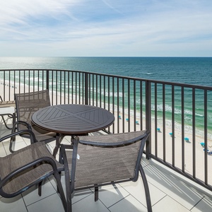 Enjoy the fresh air on the balcony, featuring a round table and chairs with stunning views of the tranquil waters