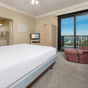 Inviting guest bedroom featuring a king bed, a TV, and balcony access with area views