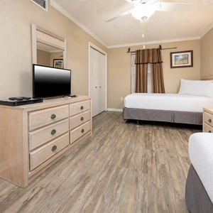 In this guest suite with two beds, enjoy evening movies or unwind beneath the gentle ceiling fan breeze