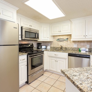 The kitchen features granite countertops, stainless appliances, Keurig, coffee maker, and charming fish decor