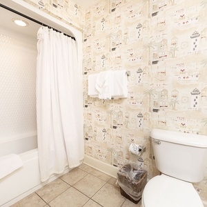 Pamper yourself in the relaxing guest bath, featuring plush towels and charming decor for a refreshing start