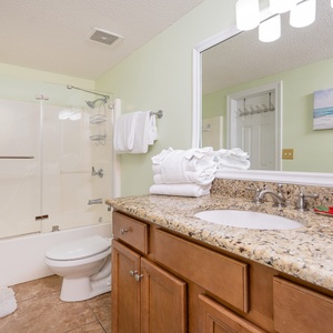Refresh in this guest bathroom featuring a spacious countertop, modern fixtures, and tub-shower combo