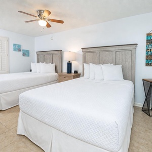 Relax in the cozy queen beds, where soft linens promise restful nights and peaceful mornings in this guest room