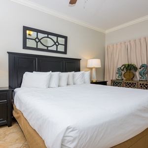 This bedroom features a plush king bed, elegant decor, and a stylish lamp, creating a serene retreat for relaxation